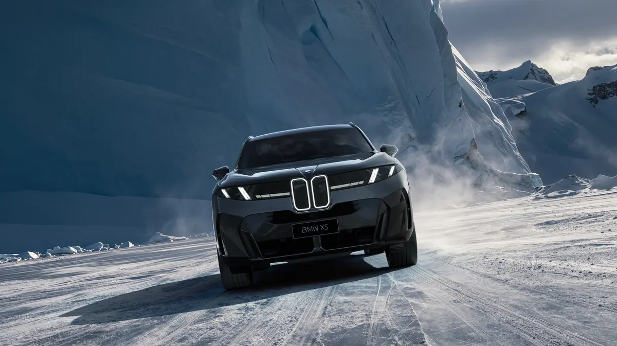 BMW X5 їде засніженою дорогою на тлі гір