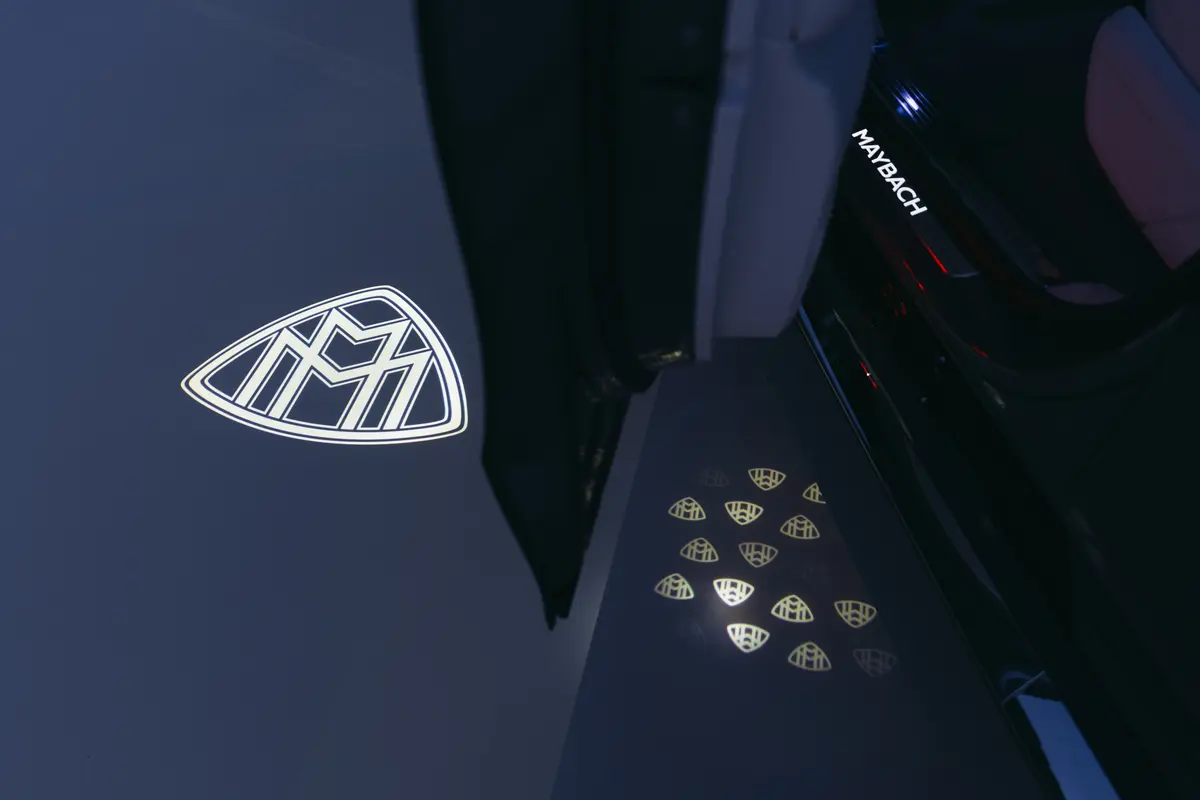 Підсвічений логотип Maybach на темному кузові авто та на порозі
